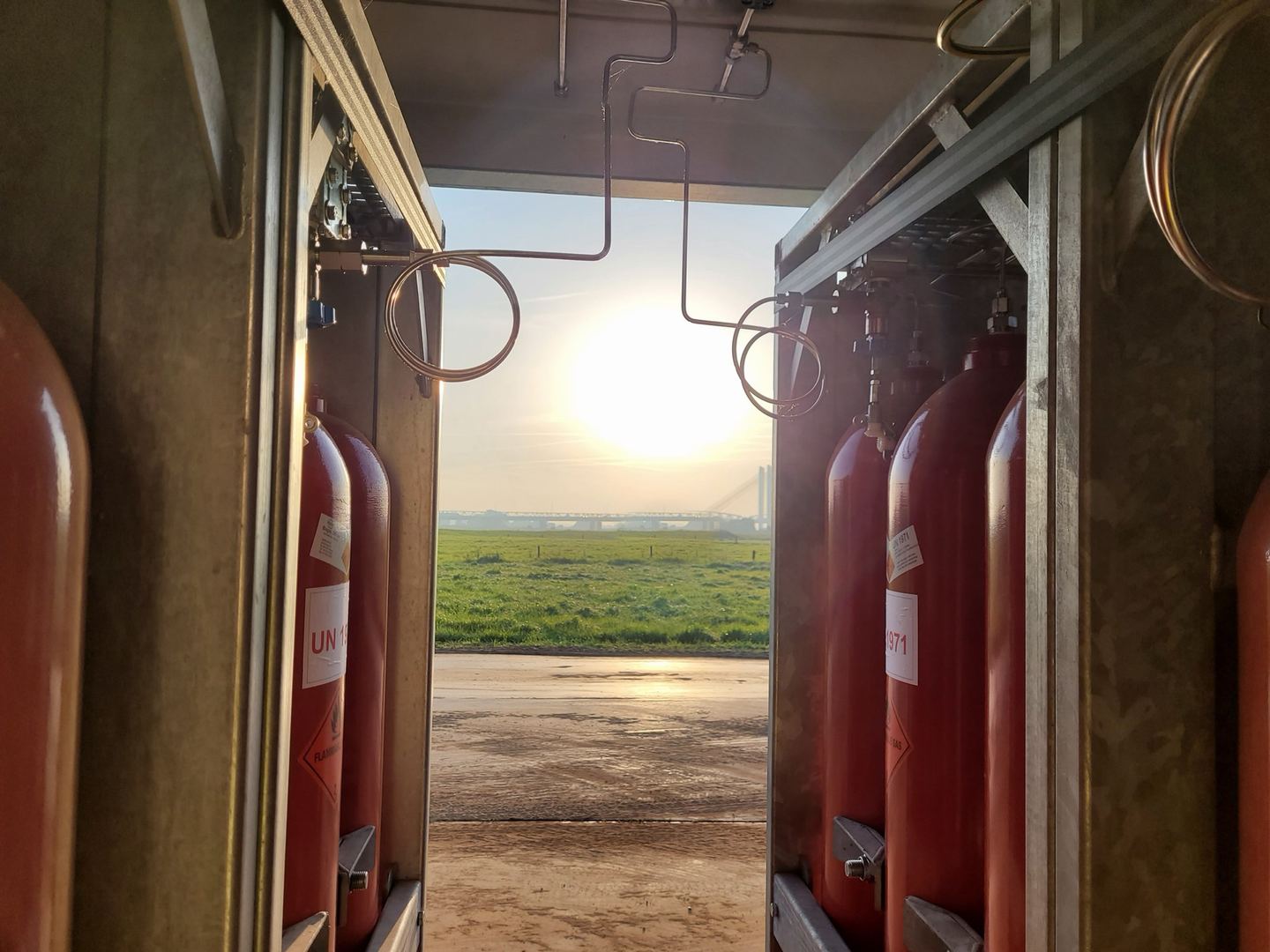 Gasflessen in een Powercrumbs-unit met uitzicht op het veld bij zonsondergang