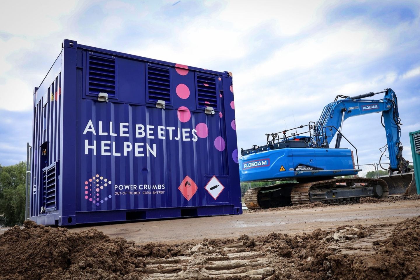 Powerbox naast een graafmachine op een bouwplaats